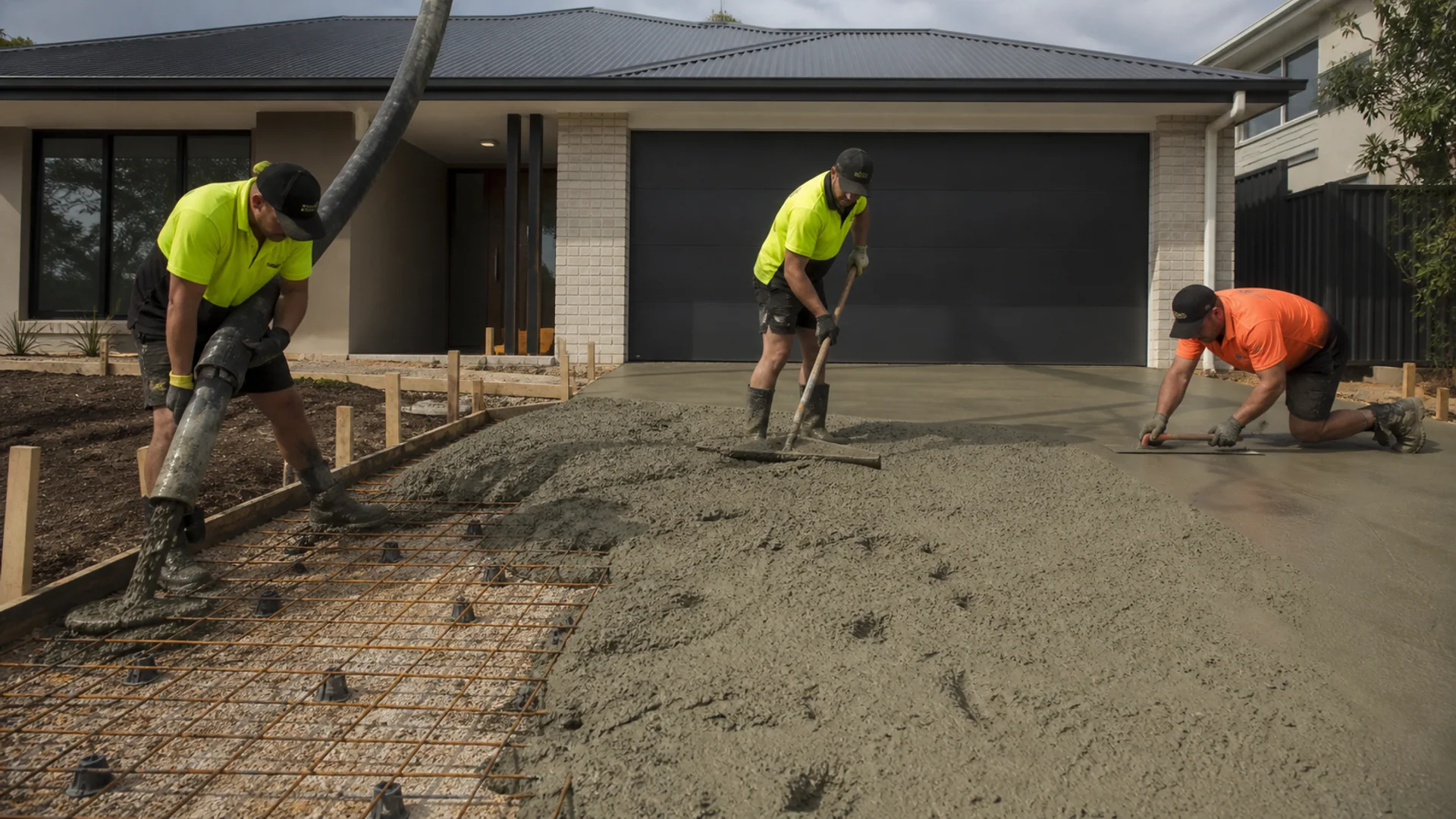 Concrete crew screeding a residential driveway pour
